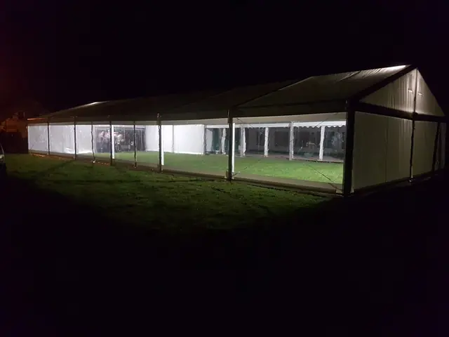 Oświetlona hala namiotowa nocą