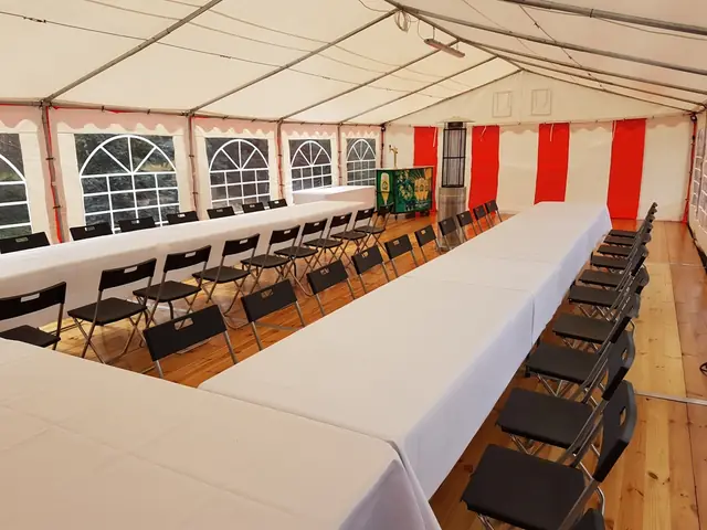 Czarne krzesła składane przy stołach cateringowych w namiocie